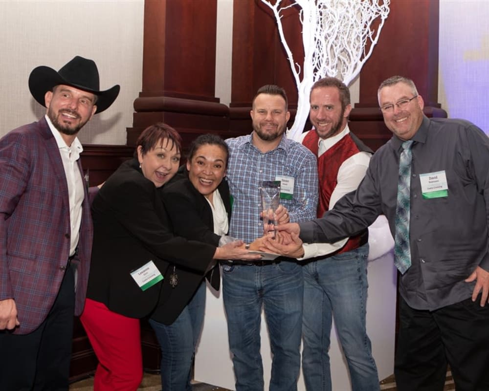 Employees posing for a photo at a charity event near Olympus Property in Fort Worth, Texas