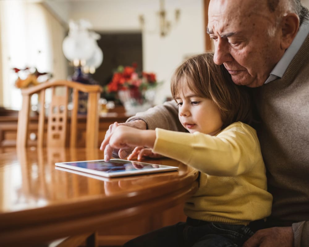 Resident and child playing games on a tablet at The Pillars of Prospect Park in Minneapolis, Minnesota