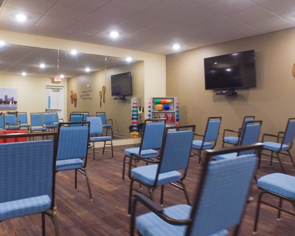 Resident fitness room with seating and large television at The Pillars of Mankato in Mankato, Minnesota