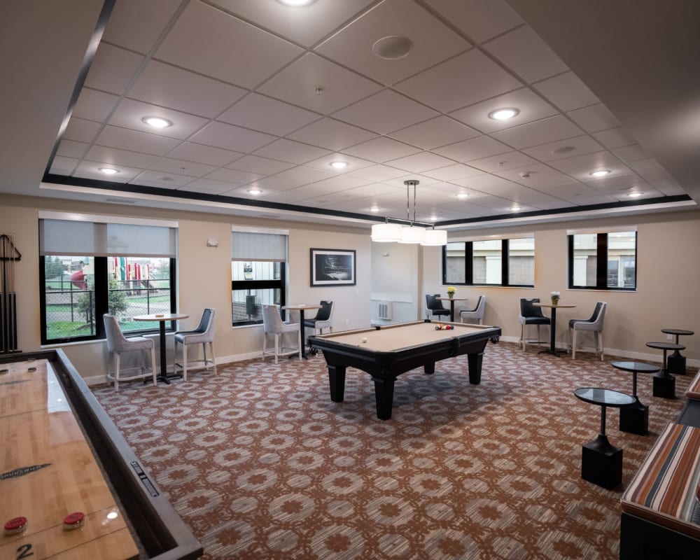 Community game room with shuffleboard and pool table at The Pillars of Lakeville in Lakeville, Minnesota