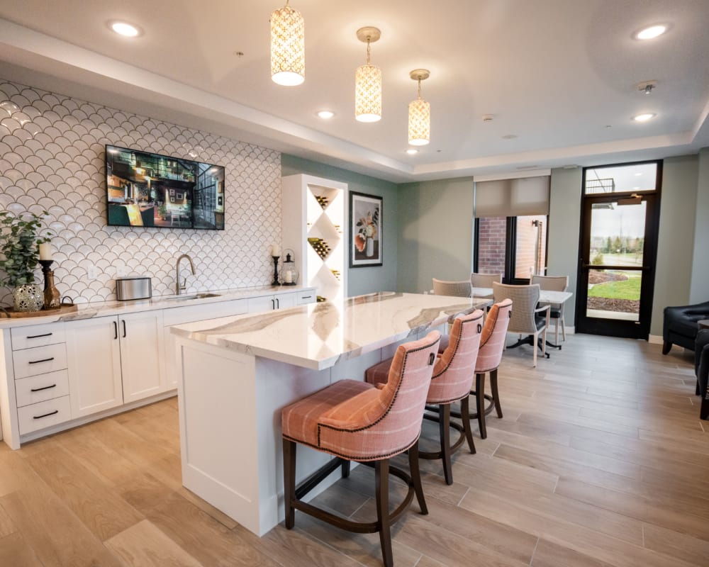 Community cafe and social area with white marble counters and counter seating at The Pillars of Lakeville in Lakeville, Minnesota