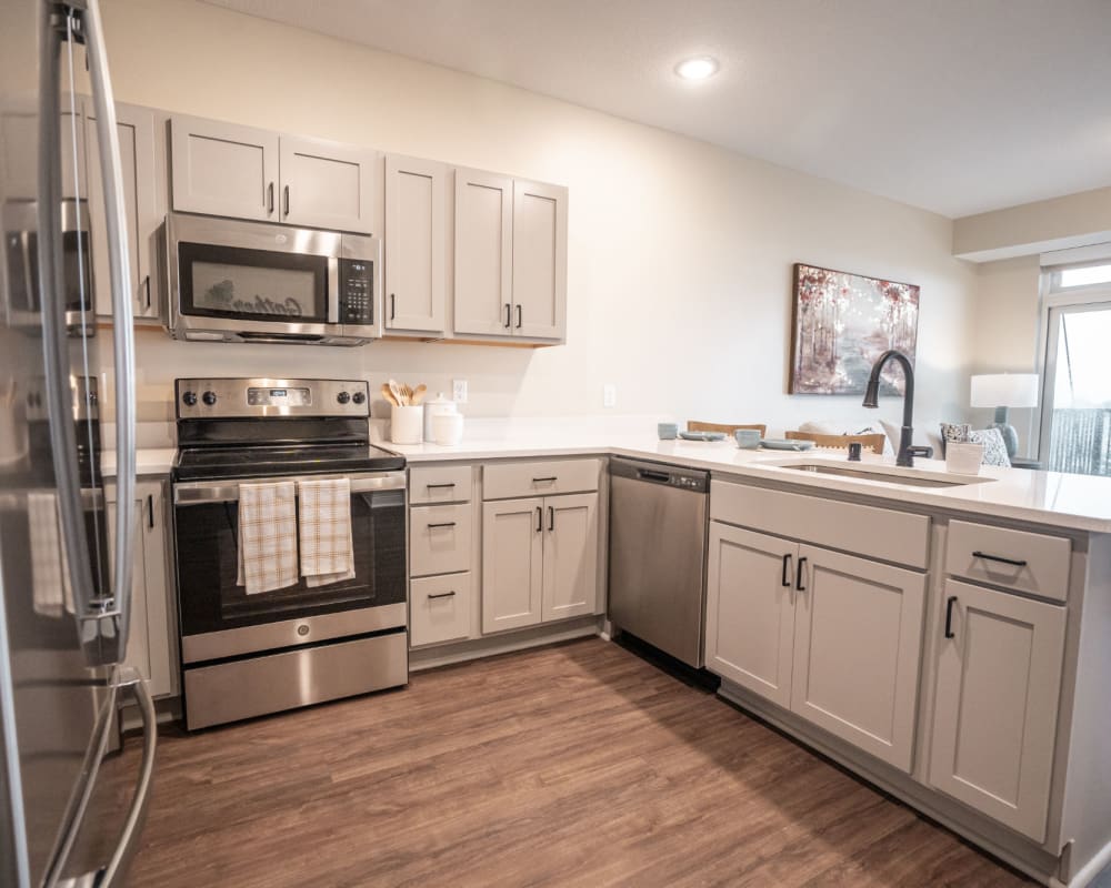 Resident apartment kitchen with stainless steel appliances at The Pillars of Lakeville in Lakeville, Minnesota