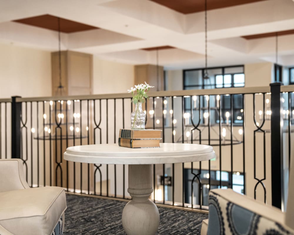 Resident seating area with leather seating and small tables at The Pillars of Lakeville in Lakeville, Minnesota