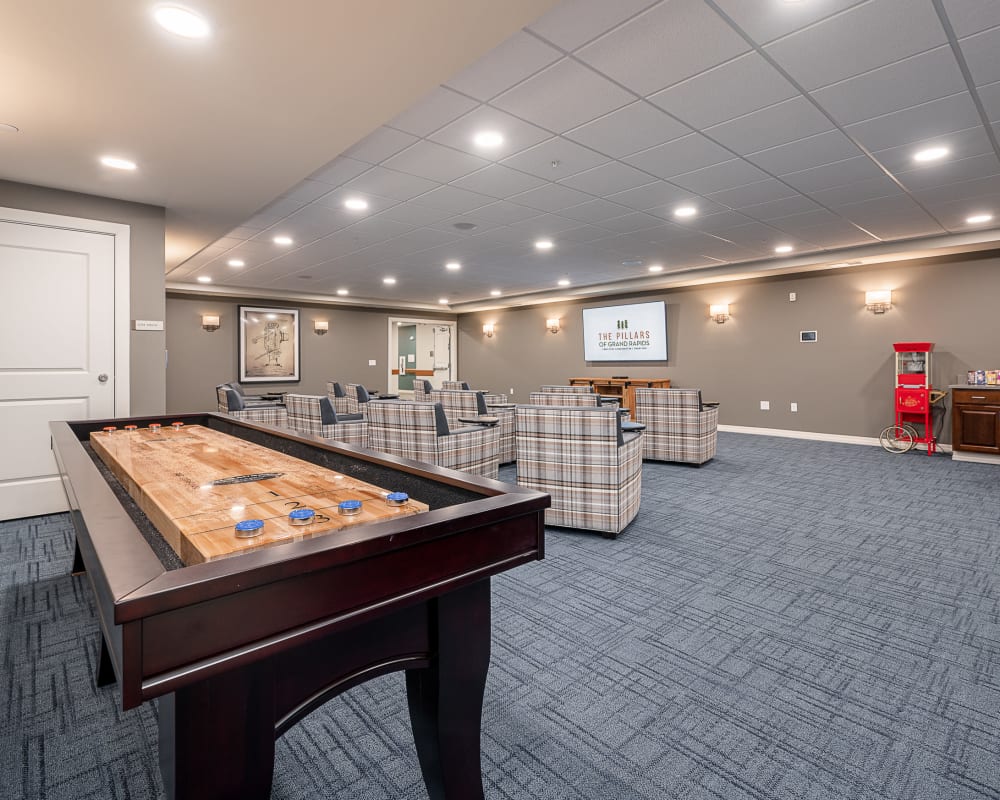 Resident recreation room with shuffleboard and other games at The Pillars of Grand Rapids in Grand Rapids, Minnesota