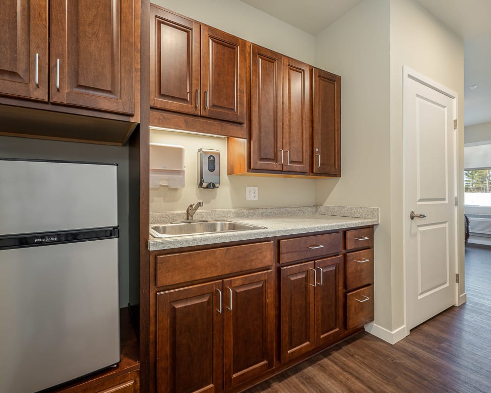 Resident kitchen with wooden cabinets and stainless steel appliances at The Pillars of Grand Rapids in Grand Rapids, Minnesota