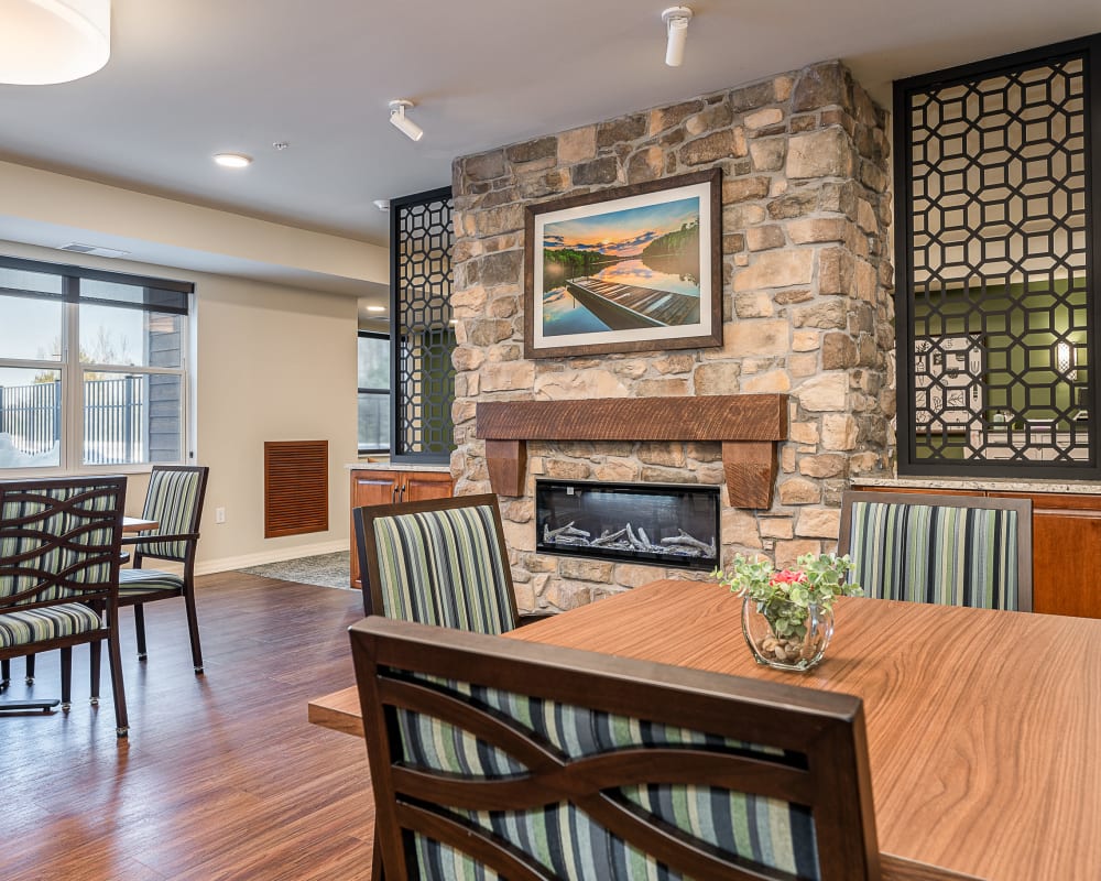 Resident dining area with electric fireplace at The Pillars of Grand Rapids in Grand Rapids, Minnesota
