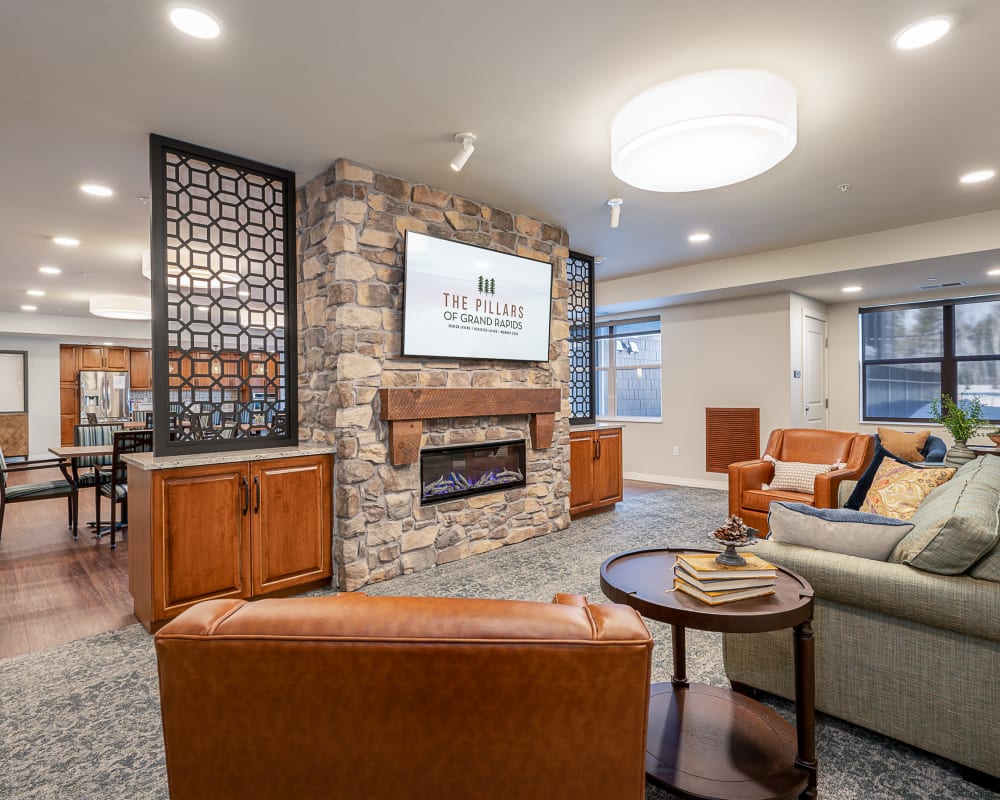 Resident lounge area with stone fireplace and large television at The Pillars of Grand Rapids in Grand Rapids, Minnesota