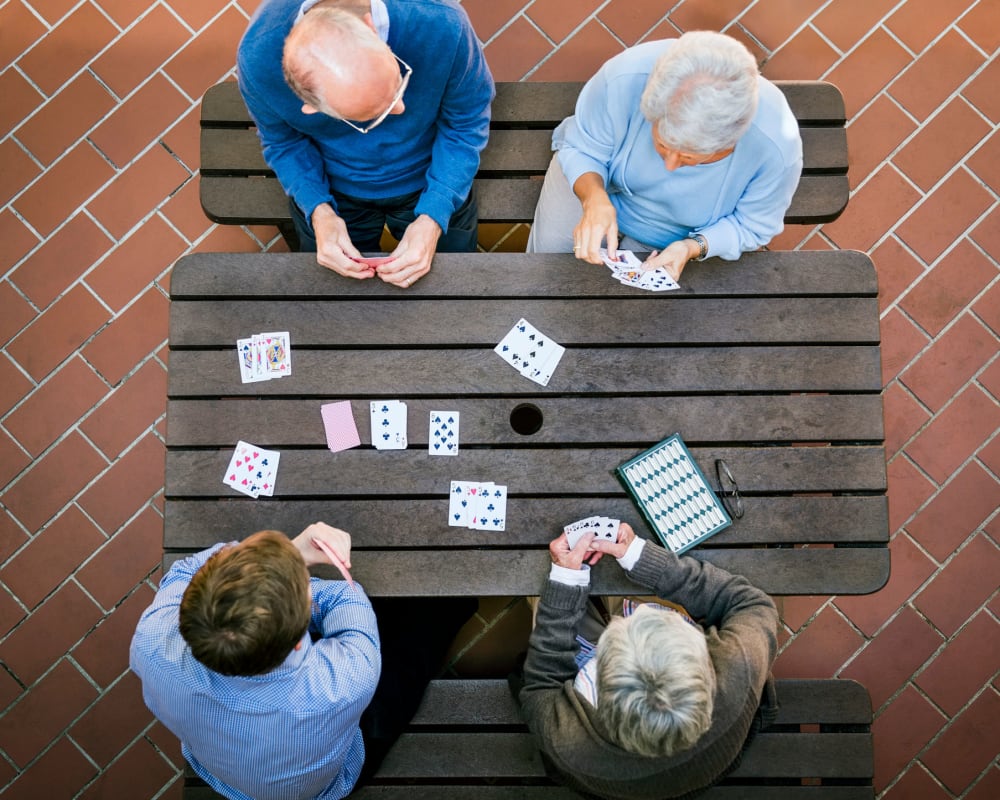 Residents outdoors playing cards at The Pillars of Hermantown in Hermantown, Minnesota