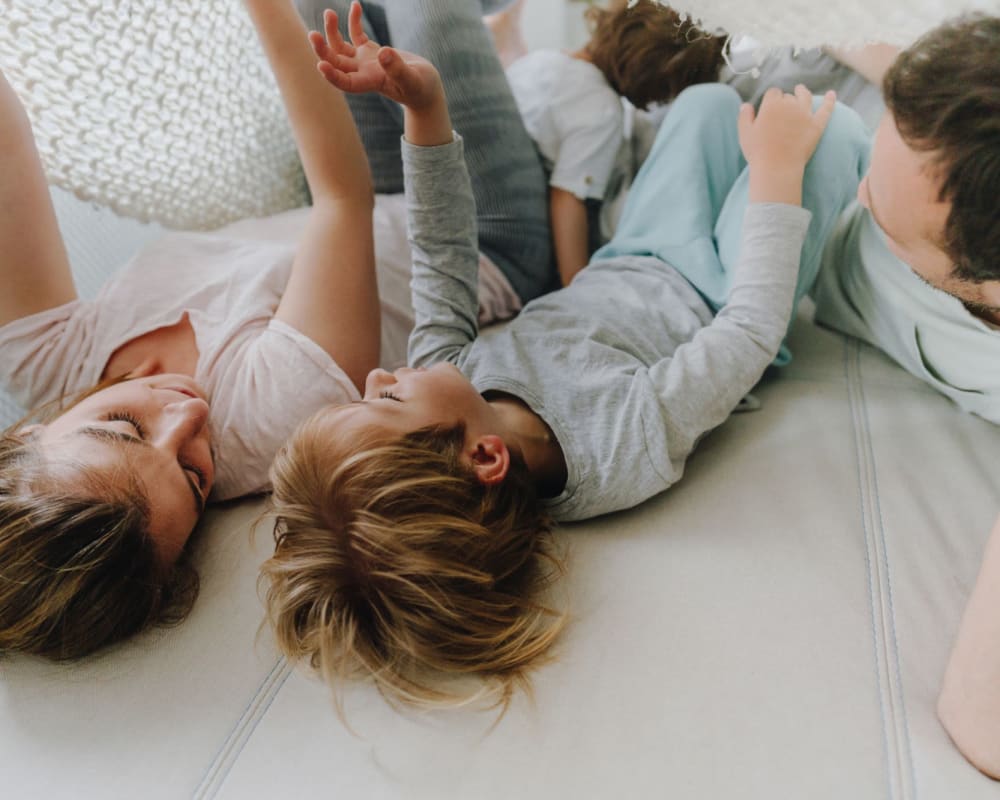 Residents playing with their son on their couch at home at Amador Apartments in Hayward, California