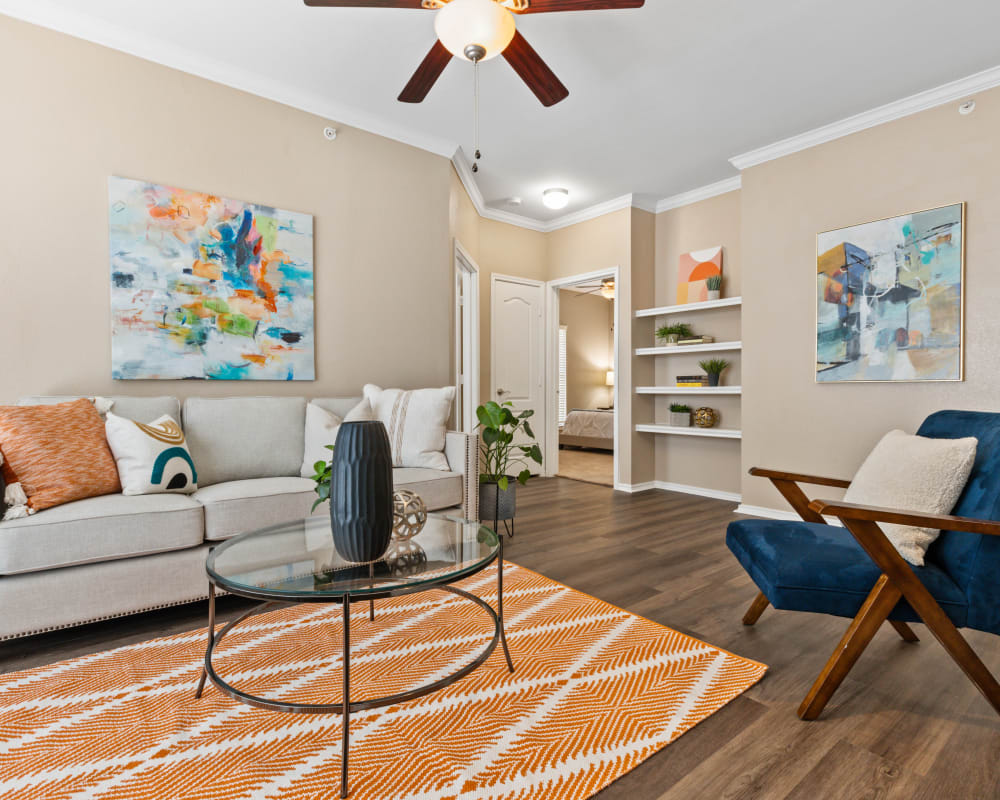 Living room with ceiling fan at El Lago Apartments 