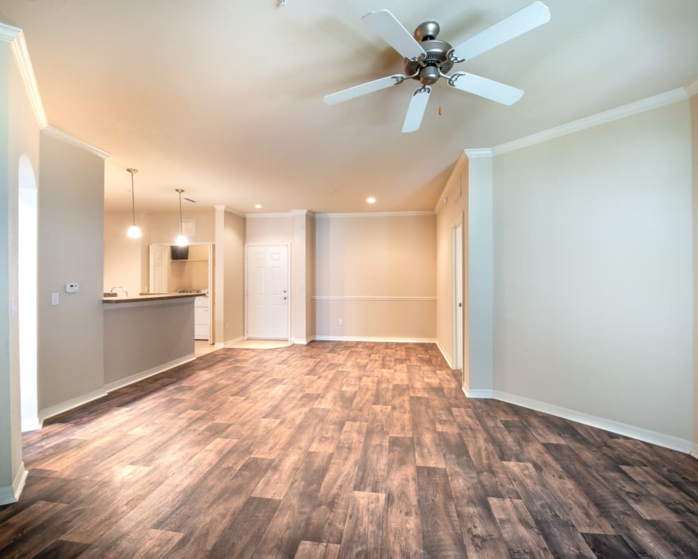 Large open-concept living area with hardwood flooring in a model home at Mirador & Stovall at River City in Jacksonville, Florida