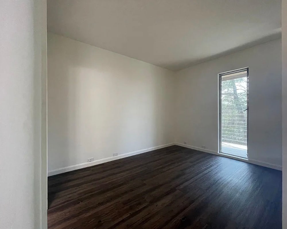 Bedroom with wood-style flooring and door to balcony at 225 Clifton in Oakland, California