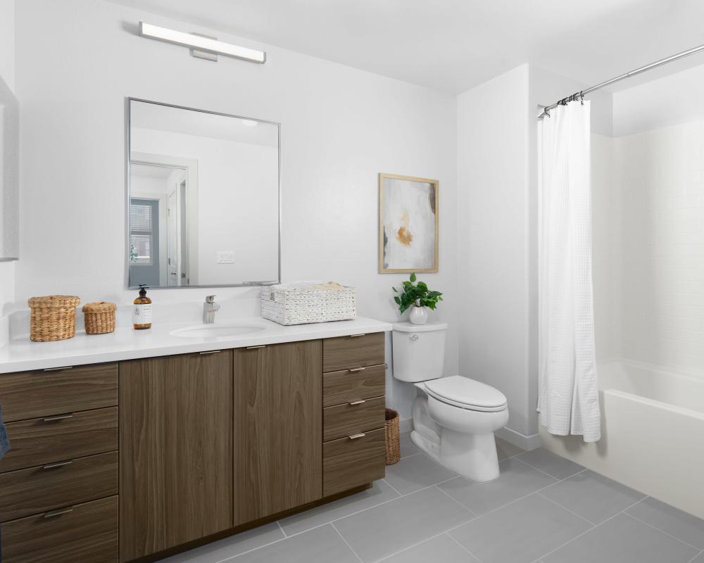 Spacious bathroom with tub, cabinet and sink at SoCo Apartments in Napa, California