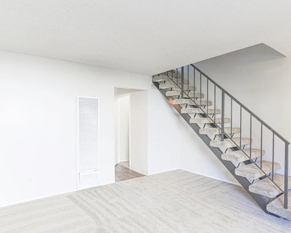 An apartment living room with stairs to the second floor at Autumn Oaks Apartments in Suisun City, California
