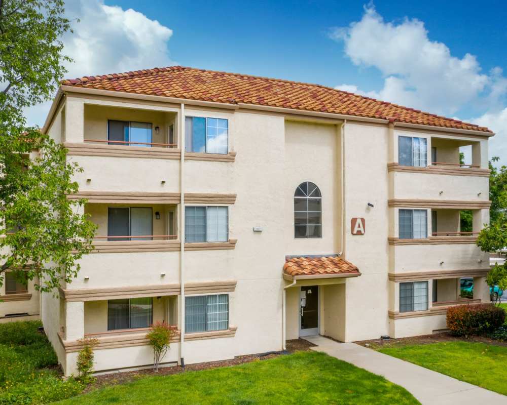 View of exterior of apartments and green lawn at Somerset Senior Apartments in Antioch, California