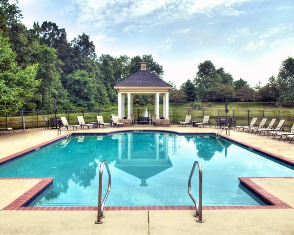 Sparkling swimming pool with an expansive sundeck and lounge chairs at Stonebridge Crossing Apartment Homes in Cordova, Tennessee