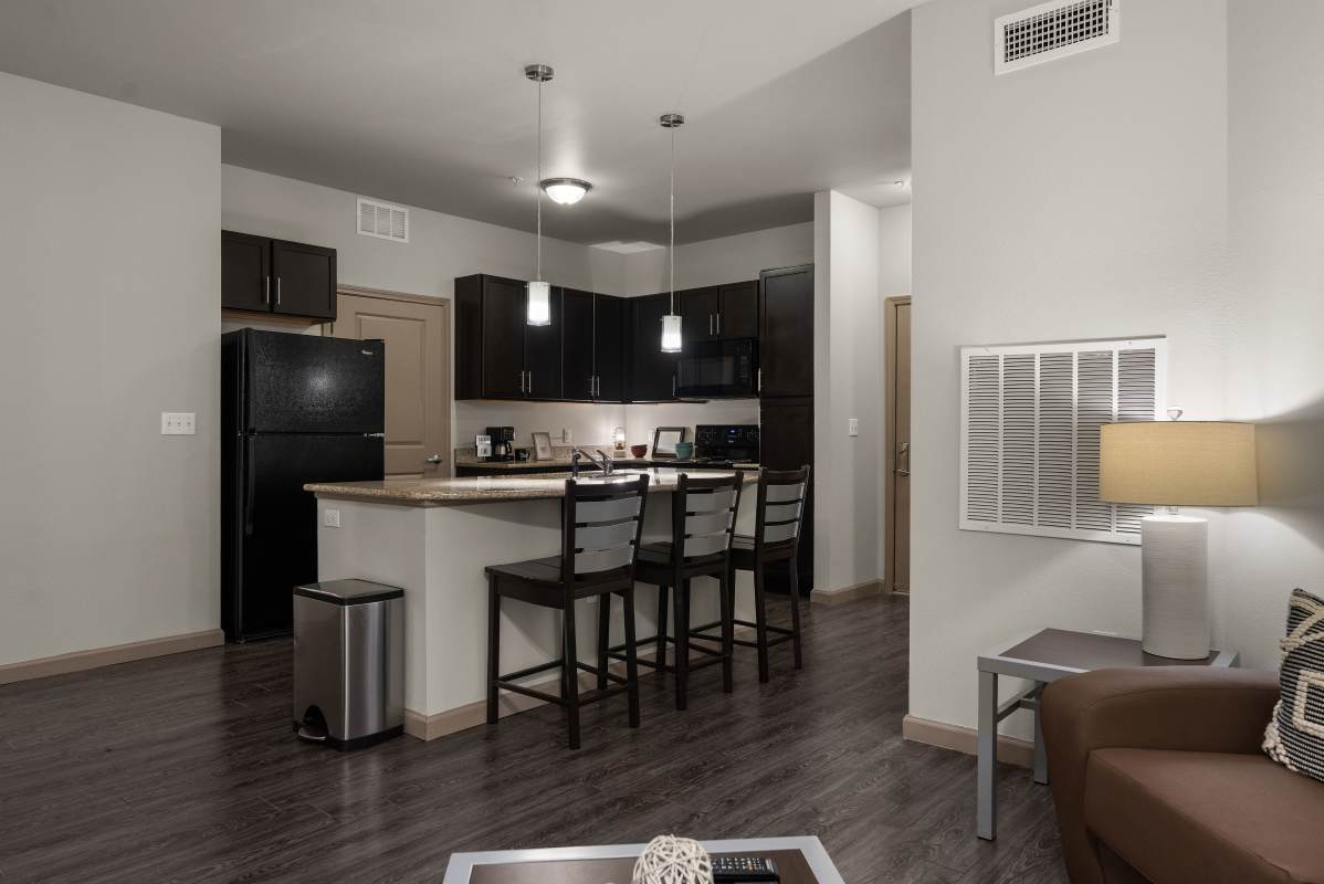 Kitchen with dark cabinets, black appliances and three-seat breakfast bar at The Den in Columbia, Missouri