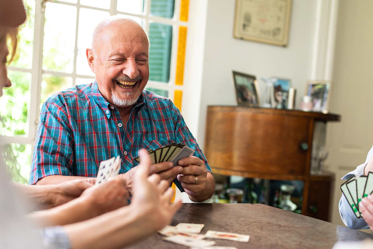 Residents enjoying playing a fun card game at a Meridian Senior Living community
