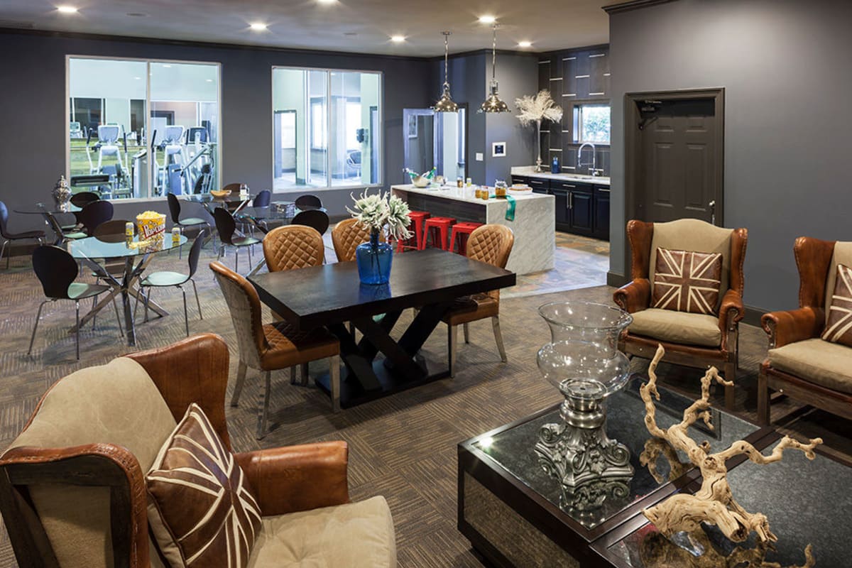 Clubhouse lounge with a partial view of the fitness center at Hyde Park at Montfort in Dallas, Texas