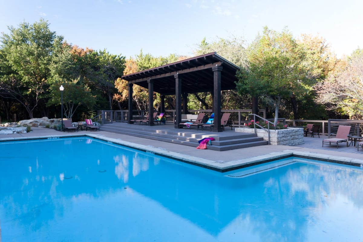 Resort-style swimming pool with shaded areas to relax nearby at Tintara at Canyon Creek in Austin, Texas