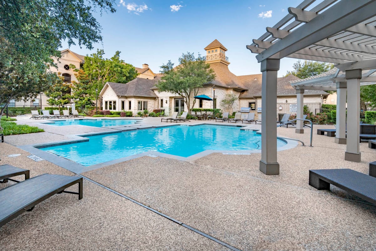 Chaise lounge chairs and a pergola near the swimming pool at Hyde Park at Montfort in Dallas, Texas