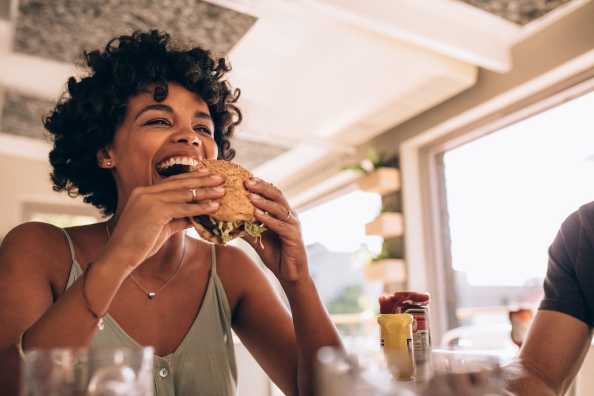 Resident eating a burger at Solace on Peachtree in Atlanta, Georgia