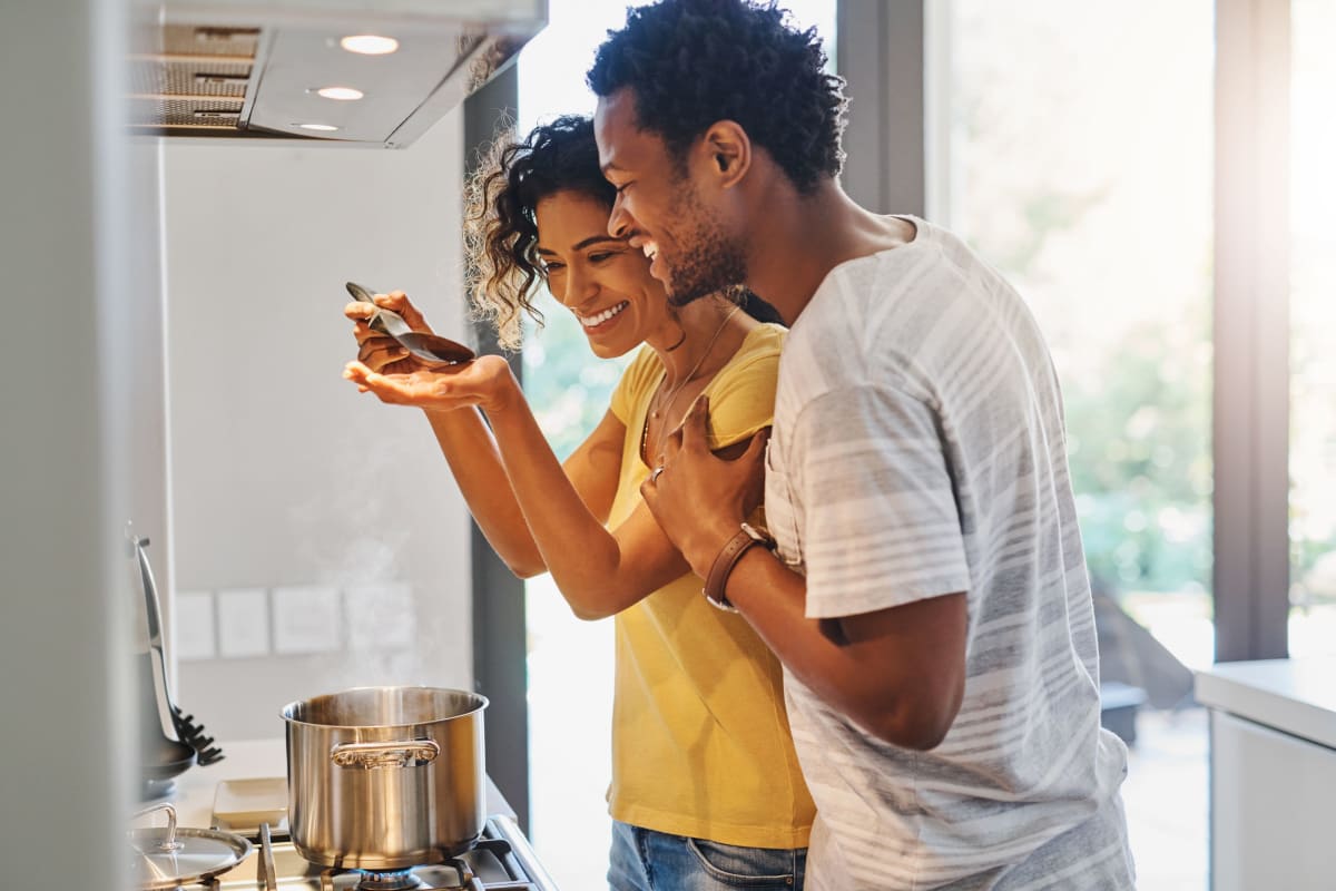 Couple cooking dinner in their kitchen at The District Flats in West Palm Beach, Florida