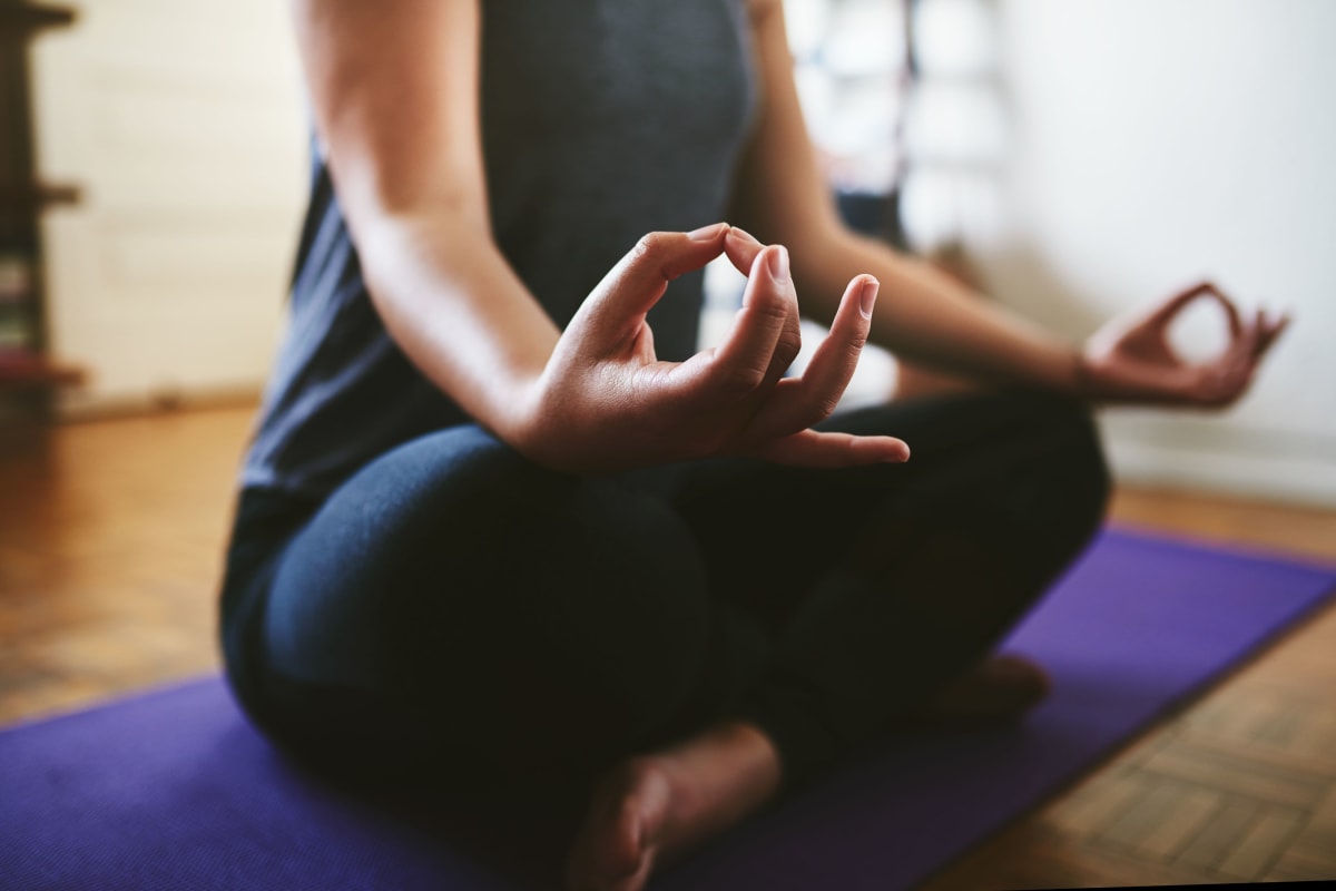 Resident doing yoga in their living room at The District Flats in West Palm Beach, Florida