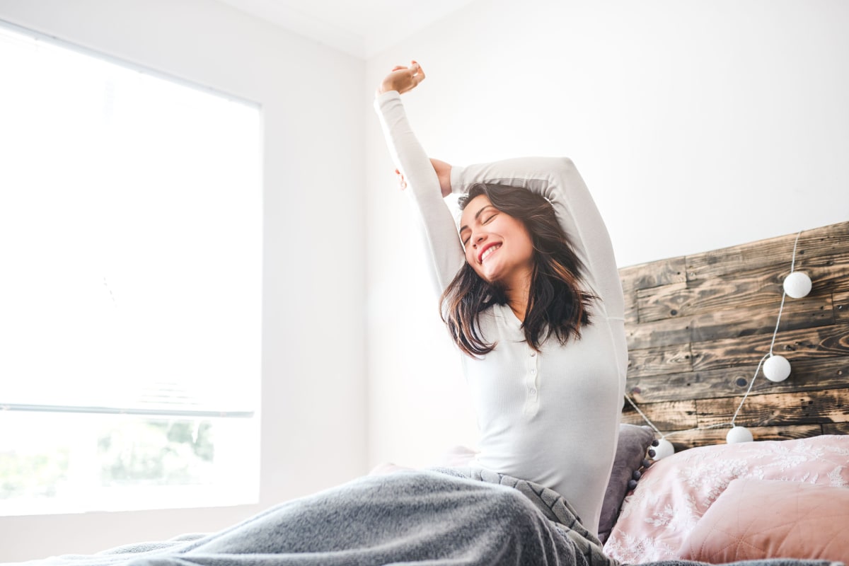 Resident stretching in her bed at The District Flats in West Palm Beach, Florida