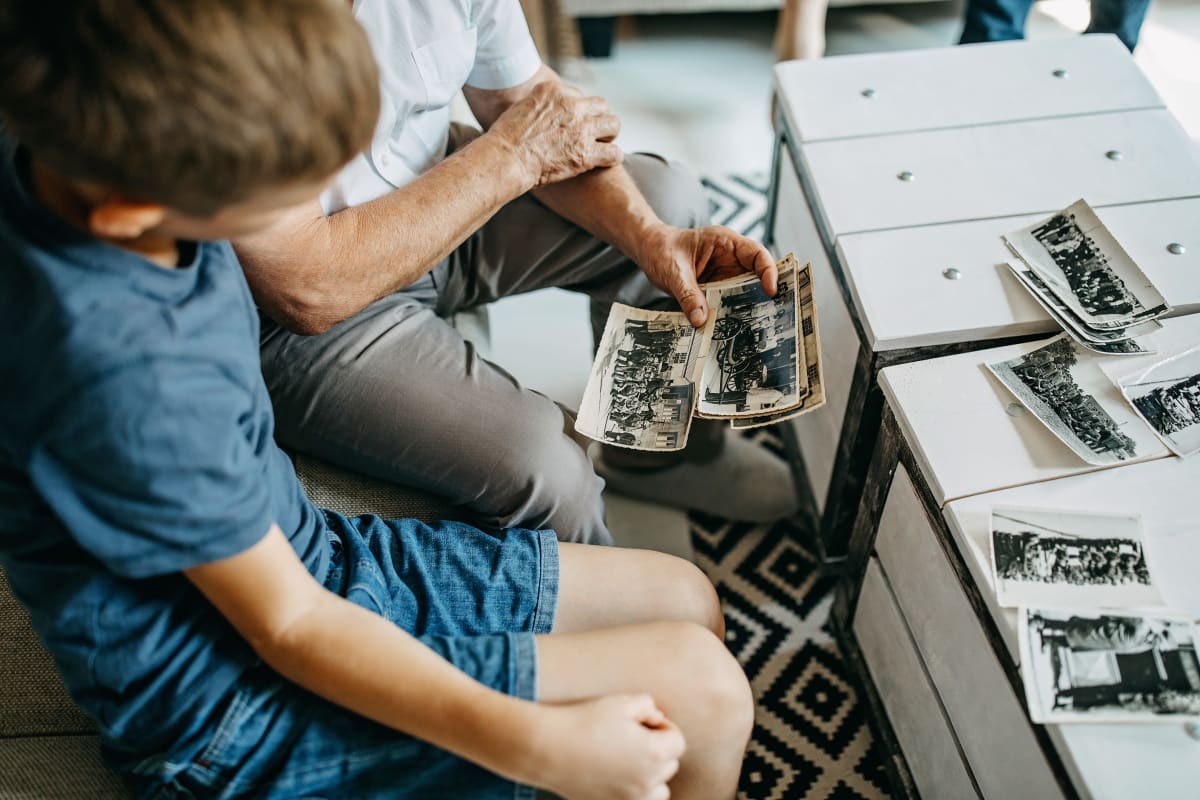 A resident showing photos to his grandson at Oxford Glen Memory Care at Grand Prairie in Grand Prairie, Texas