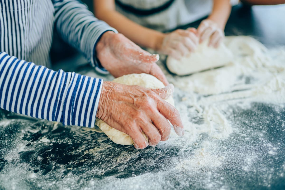 Two people kneading dough at The Oxford Grand Assisted Living & Memory Care in McKinney, Texas