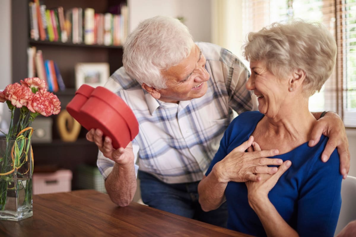 Man giving his wife a gift at Oxford Villa Active Senior Apartments in Wichita, Kansas