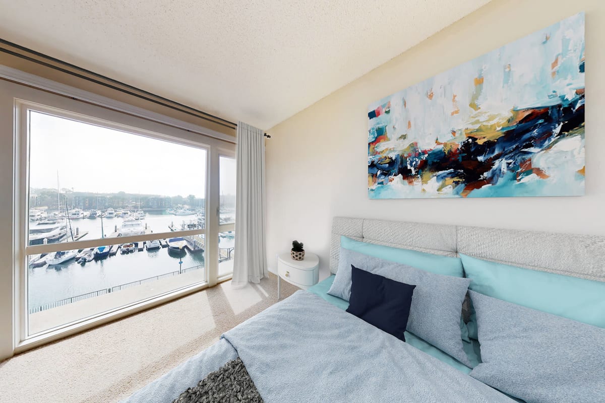 Spacious bedroom with waterfront views of the marina at The Tides at Marina Harbor in Marina del Rey, California