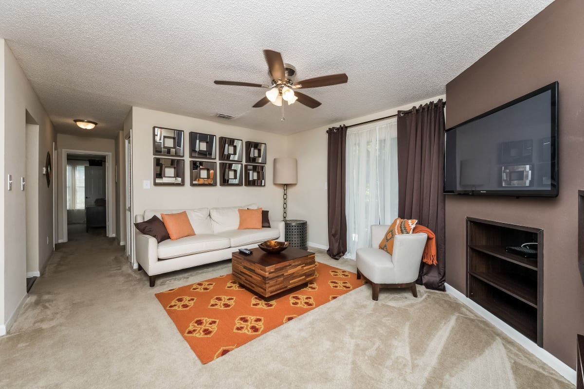 Spacious living room with a ceiling fan and built-in shelving at Tuscany Pointe at Tampa Apartment Homes in Tampa, Florida