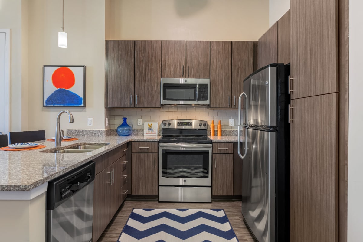 Modern kitchen with stainless steel appliances and granite countertops at Marq at Crabtree in Raleigh, North Carolina