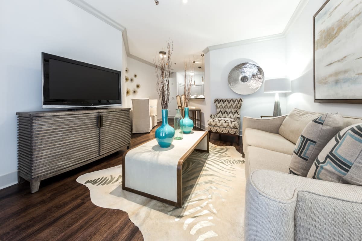 Full size couch, coffee table, entertainment center, and single chair in living room at Marq Eight in Atlanta, Georgia