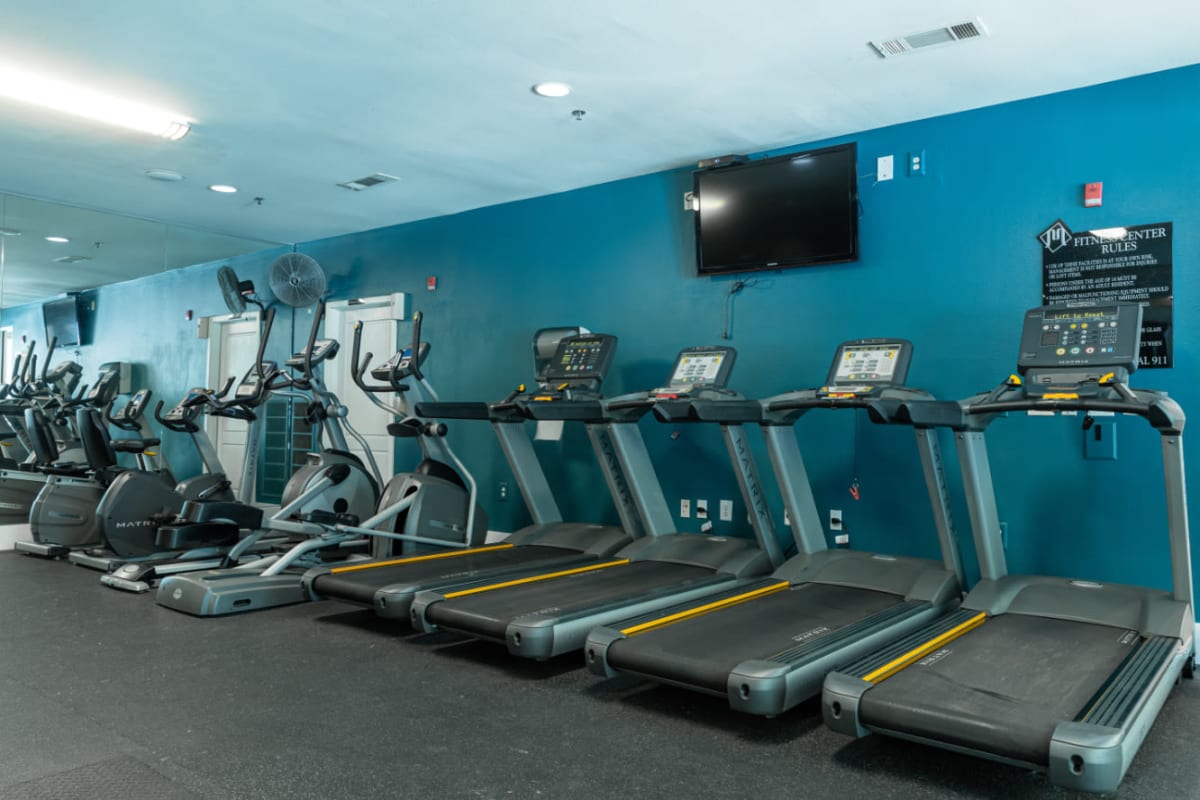 Cardio machines lined up against the wall at Marquis at Texas Street in Dallas, Texas