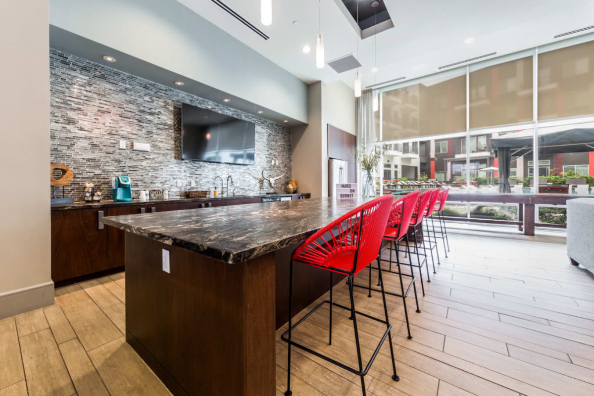Granite counter with bar stool chairs in community clubhouse kitchen area at Marq on Burnet in Austin, Texas