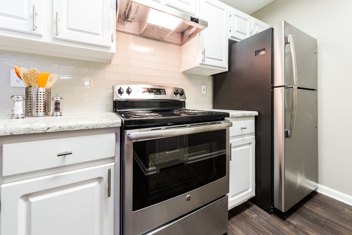 Stainless steel appliances set in white cabinets with granite countertops at The Marq at Brookhaven in Atlanta, Georgia