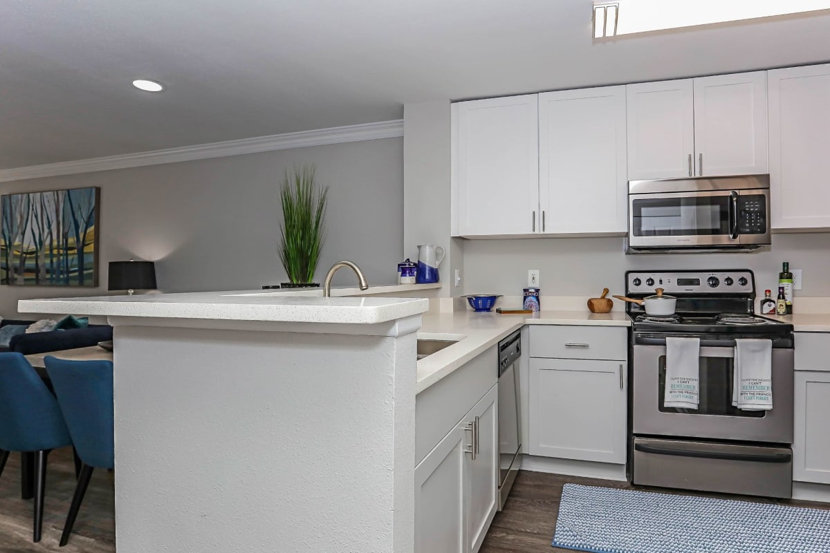 Large kitchen with nice white cabinets and wood style flooring at 45Eighty Dunwoody Apartment Homes in Dunwoody, Georgia