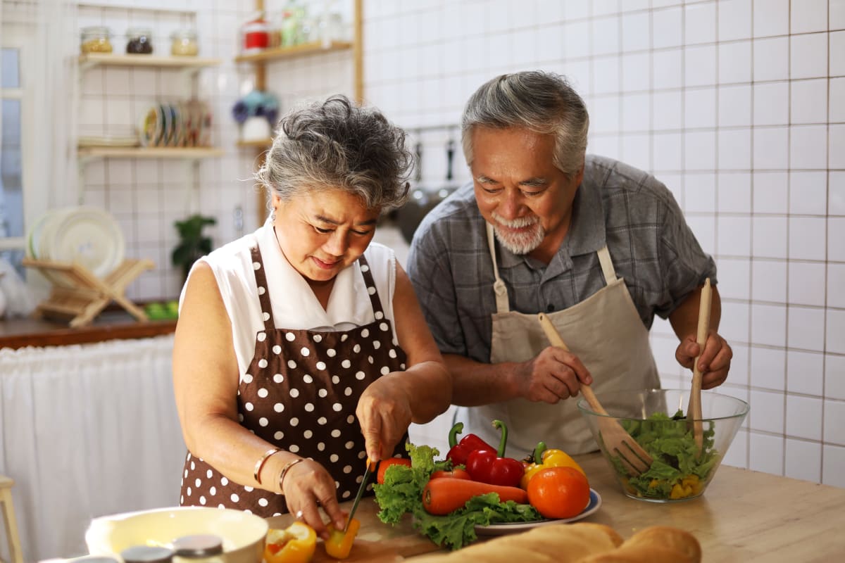 Residents cooking in their senior living apartment at Monark Grove Clarkston in Clarkston, Michigan