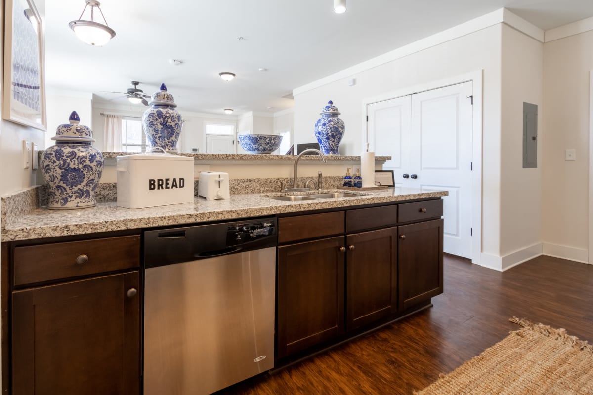 Gourmet kitchen with granite countertops and dishwasher at The Waverly in Newark, Delaware