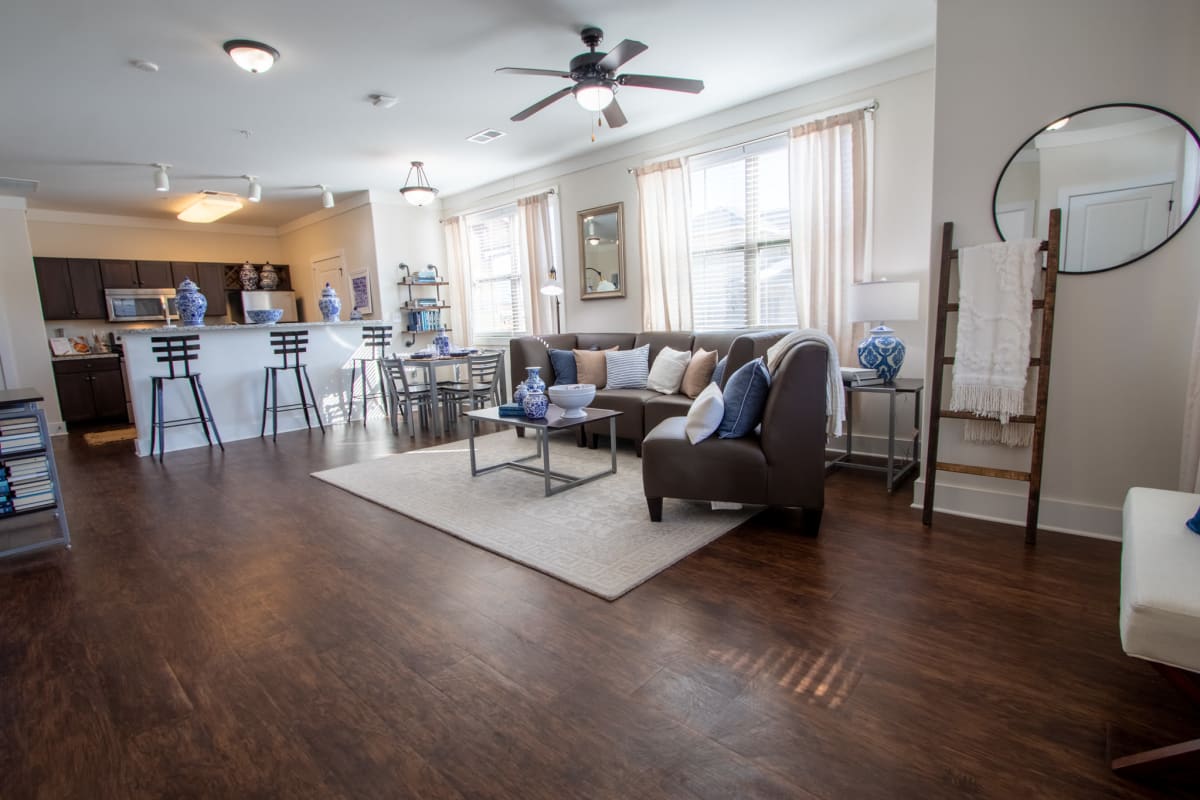 Open living room and kitchen with a ceiling fan and wood-style flooring at The Waverly in Newark, Delaware