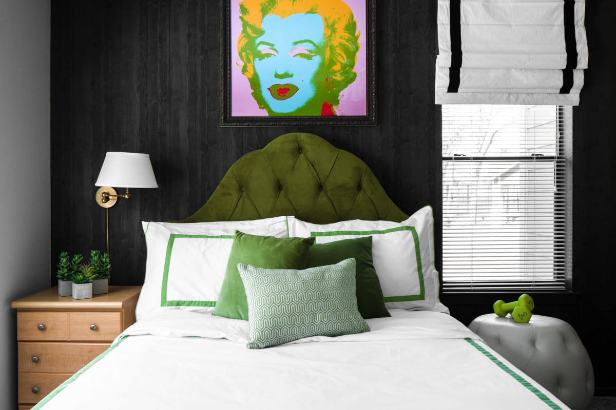 Model bedroom with a blue accent wall and popart poster at The London in College Station, Texas