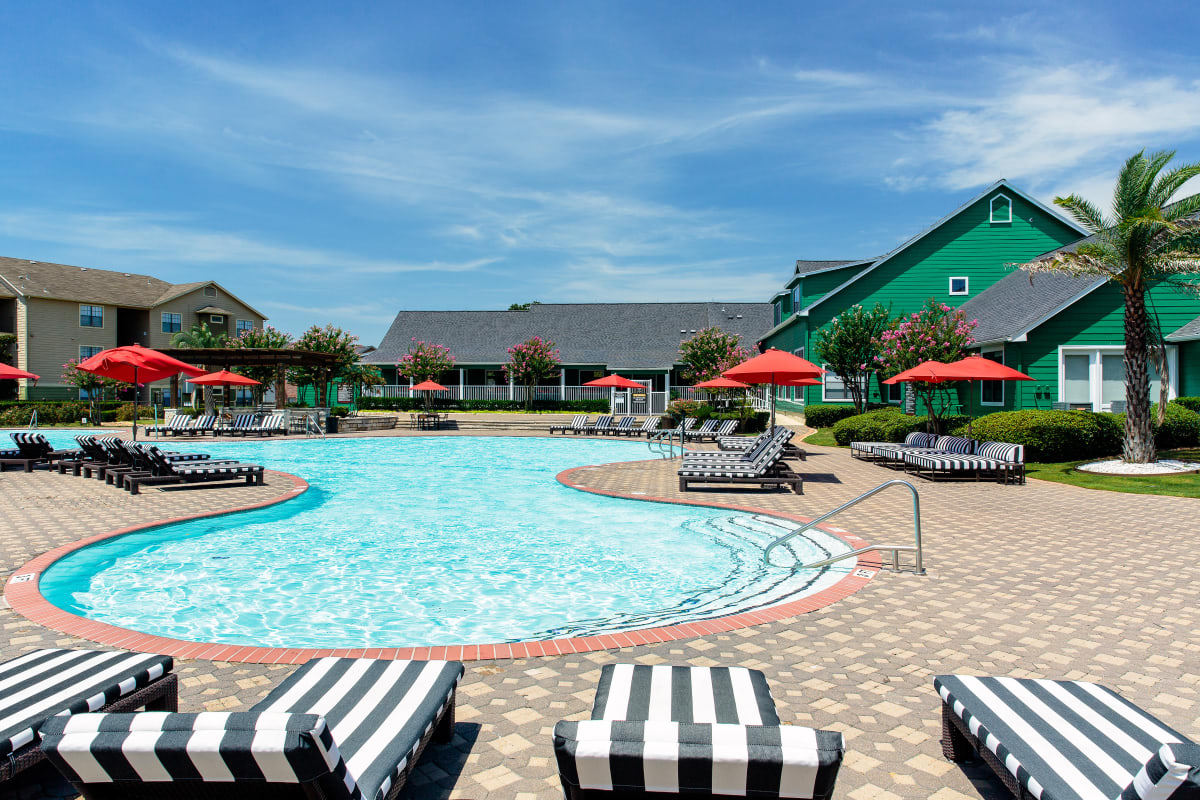 Resort-style pool surrounded by striped lounge chairs at The London in College Station, Texas