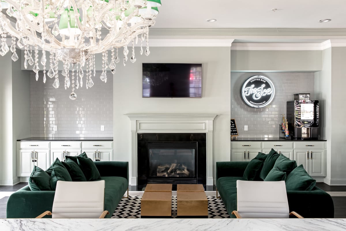 Velvet sofas in front of a fireplace in the boutique clubhouse at University Village in Greensboro, North Carolina