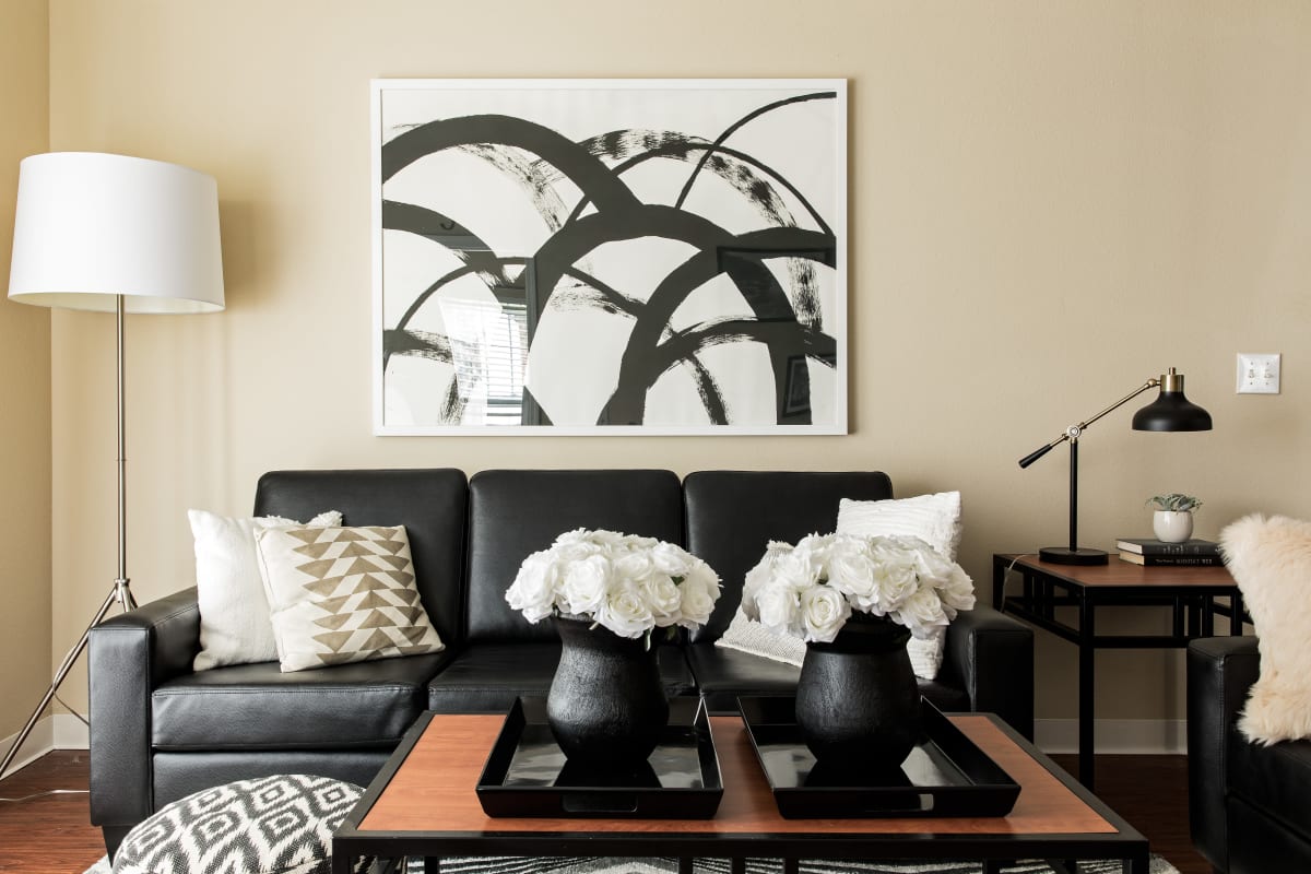 Living room with abstract artwork and a leather sofa at University Village in Greensboro, North Carolina