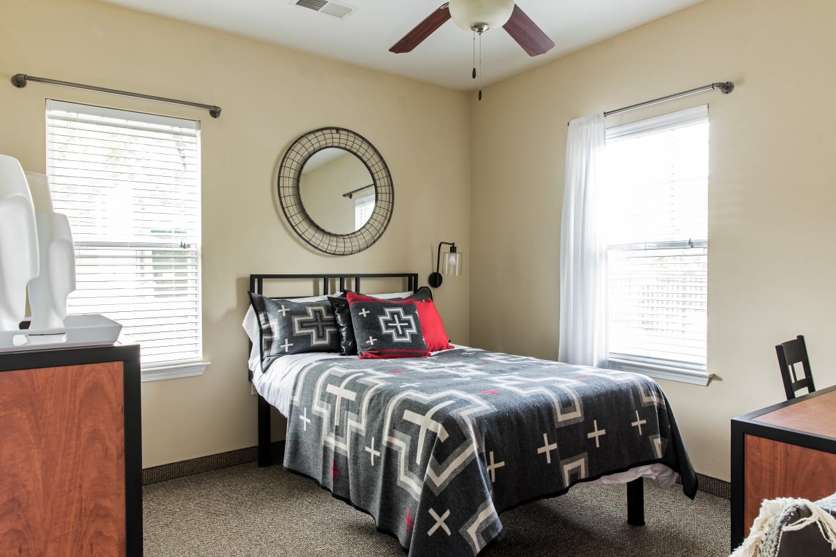 Spacious student bedroom with a ceiling fan at University Village in Greensboro, North Carolina
