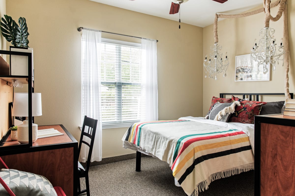 Model bedroom with a ceiling fan at University Village in Greensboro, North Carolina