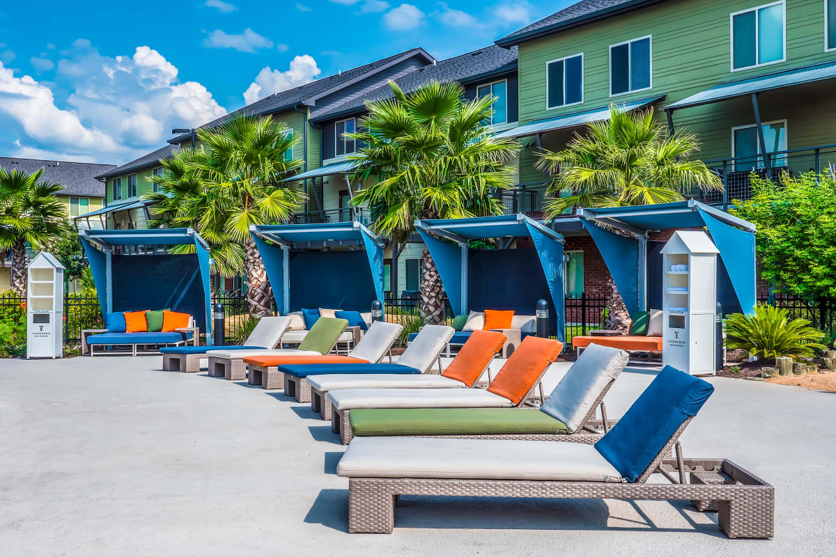 Resort-inspired lounge chairs and plush covered cabanas by the pool at The Thompson in San Marcos, Texas